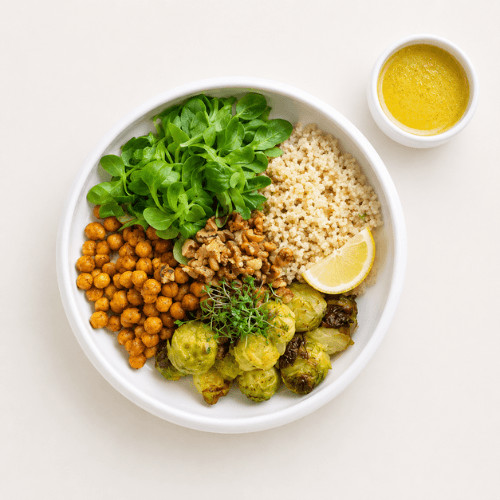 Vegane Rosenkohl-Quinoa-Bowl mit Kichererbsen, Walnüssen und Ahorn-Senf-Dressing, warm angerichtet