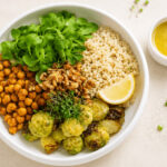 Vegane Rosenkohl-Quinoa-Bowl mit Kichererbsen, Walnüssen und Ahorn-Senf-Dressing, warm angerichtet