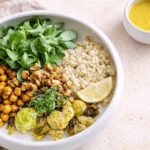 Vegane Rosenkohl-Quinoa-Bowl mit Kichererbsen, Walnüssen und Ahorn-Senf-Dressing, warm angerichtet