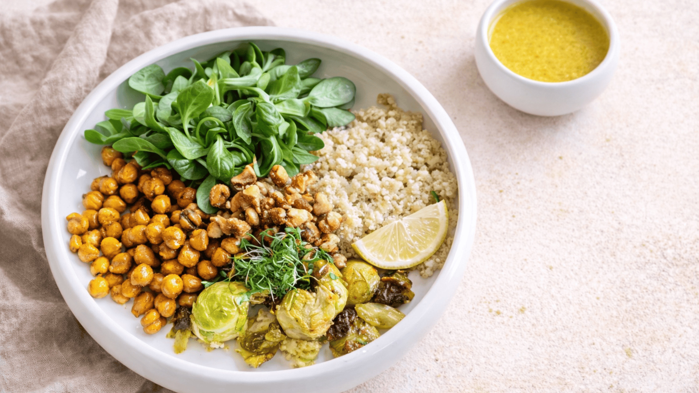 Vegane Rosenkohl-Quinoa-Bowl mit Kichererbsen, Walnüssen und Ahorn-Senf-Dressing, warm angerichtet