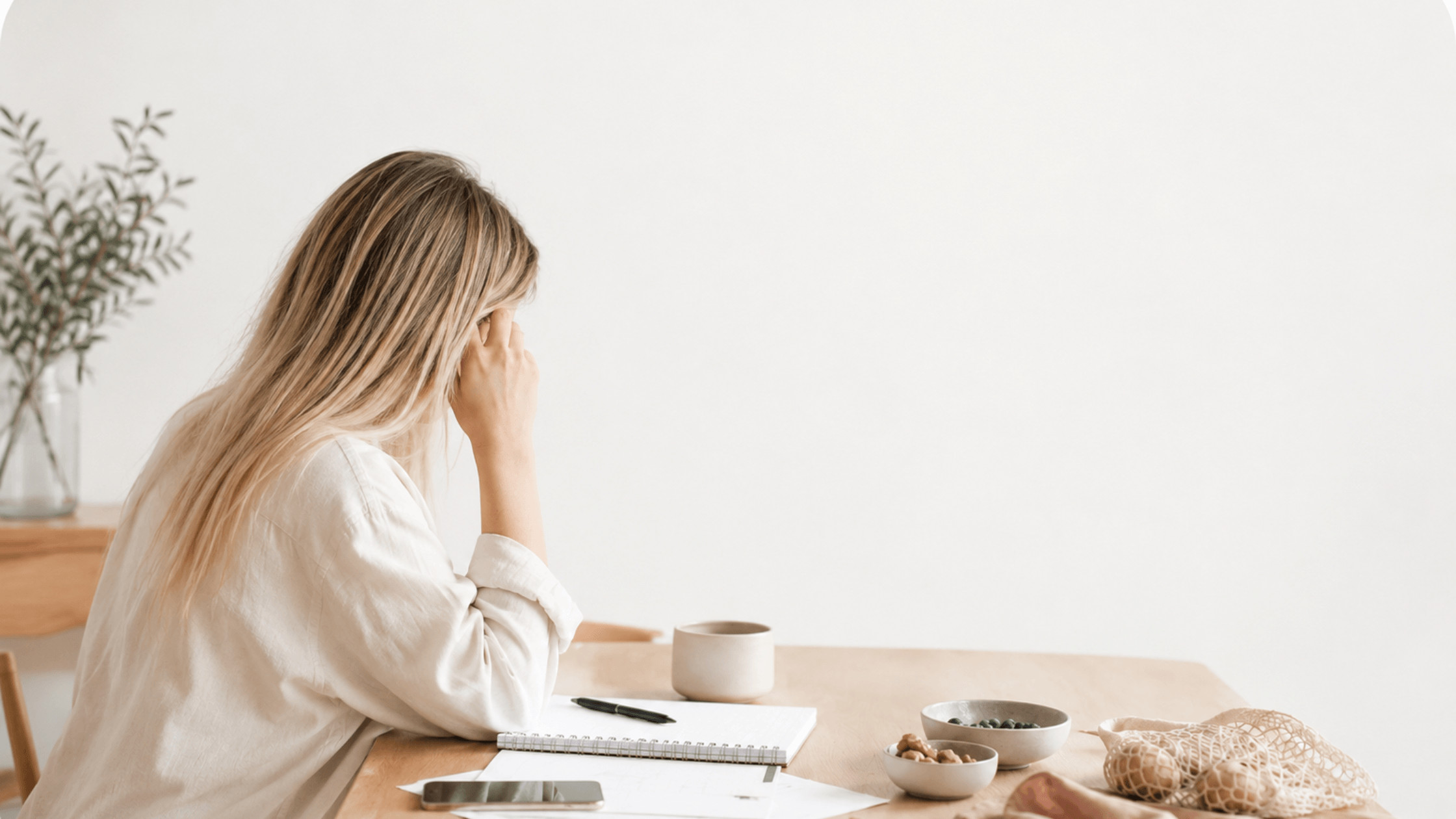 Frau im Alltag, die unter Mental Load steht und Schwierigkeiten hat, sich regelmäßig und gesund zu ernähren. Helle, natürliche Darstellung von Frauengesundheit, Ernährung, Stress und Alltagsbelastung. Symbolische Darstellung dafür, wie Erschöpfung, Decision Fatigue und mentale Last gesunde Ernährung im Alltag beeinflussen.