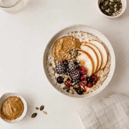 Pflanzliches Frühstück mit Haferflocken, Beeren und Nüssen – nährstoffreiche Mahlzeit für eine gesunde Darmflora.