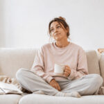 Gesunde Ernährung, leerer Akku? Das sollten Frauen wissen Ständig müde trotz gesunder Ernährung: Frau erschöpft auf dem Sofa – Müdigkeit bei Frauen, Energie, Nährstoffe und Ernährung im Alltag